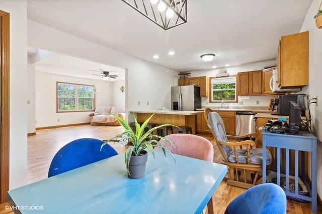 dining area featuring ceiling fan, sink, and light hardwood / wood-style flooring