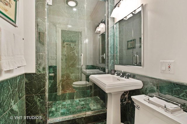 bathroom with a stall shower, tile walls, and toilet