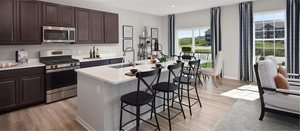 1376 Keller St, Elburn, IL 60119 - kitchen with stainless steel appliances, light wood-type flooring, a breakfast bar area, and light countertops