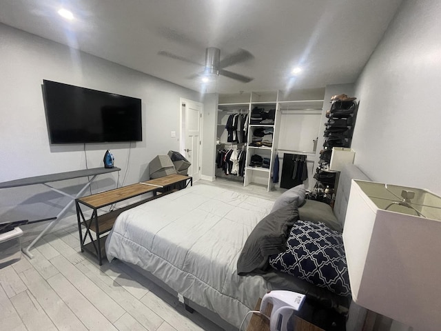 bedroom with a closet, ceiling fan, and light wood-style floors