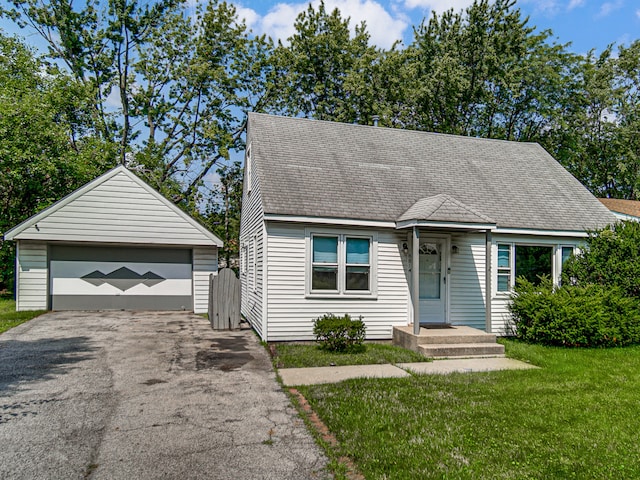 view of front facade with a garage, a front lawn, and an outbuilding