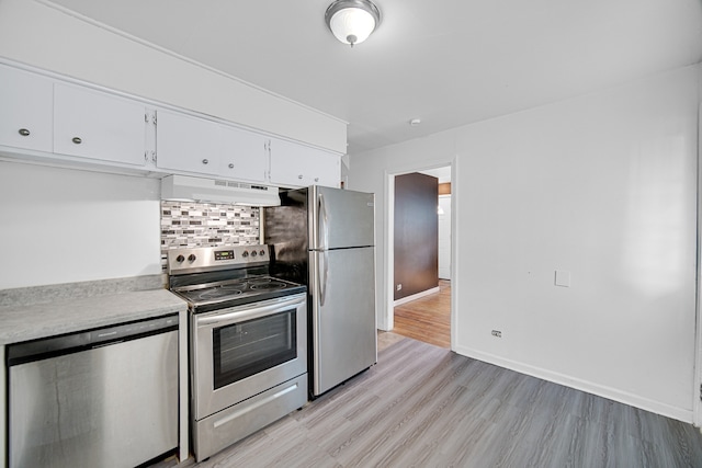 kitchen with white cabinetry, stainless steel appliances, backsplash, and light wood-type flooring