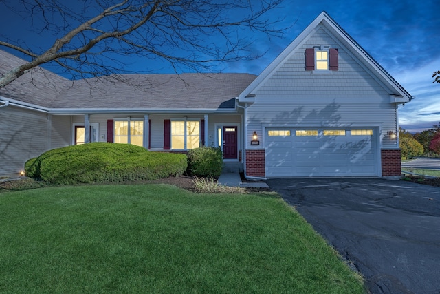 view of front of property with a garage and a lawn