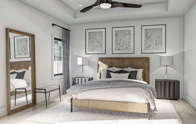 bedroom with light hardwood / wood-style flooring, ceiling fan, and a raised ceiling