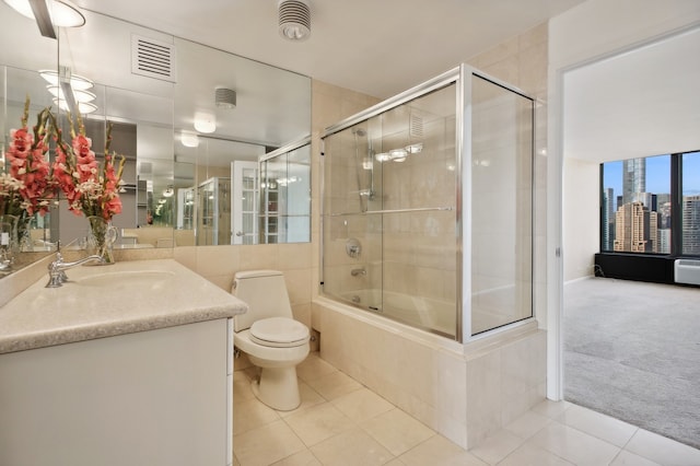 full bathroom featuring vanity, shower / bath combination with glass door, toilet, and tile patterned flooring