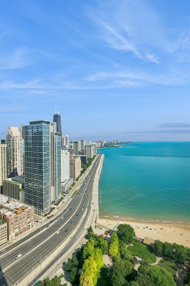 drone / aerial view featuring a view of city, a water view, and a view of the beach