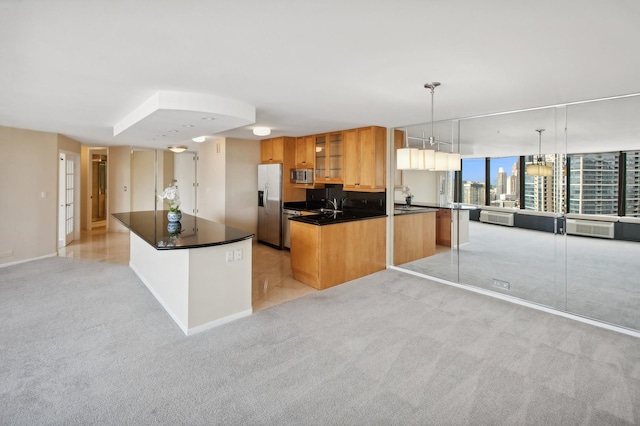 kitchen with a center island, dark countertops, light colored carpet, appliances with stainless steel finishes, and glass insert cabinets