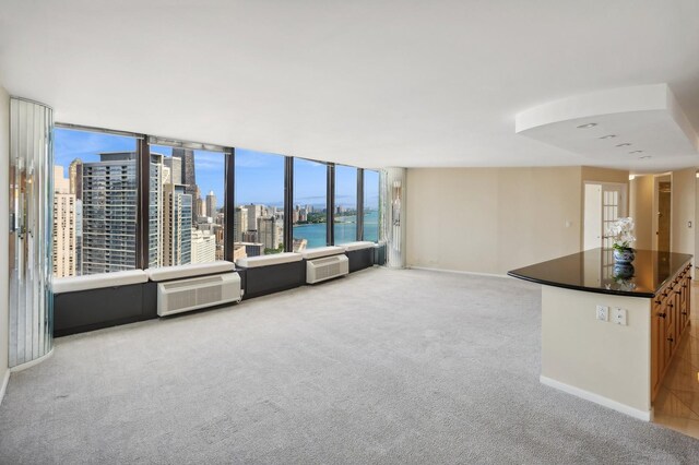 unfurnished living room with a water view and light colored carpet