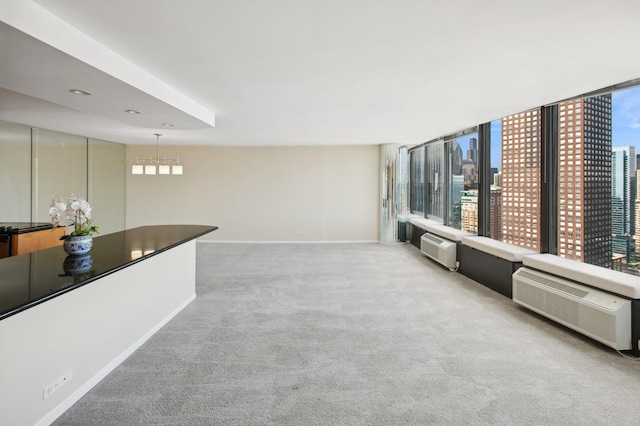 living room with baseboards, a city view, carpet, and a healthy amount of sunlight