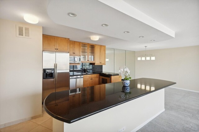 kitchen featuring decorative light fixtures, light colored carpet, appliances with stainless steel finishes, and sink