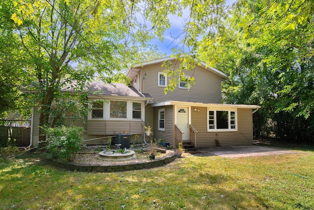 back of property with a lawn and central AC unit