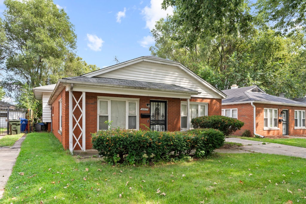 bungalow-style home featuring a front lawn