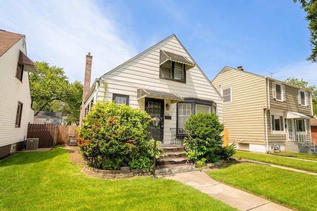 bungalow-style house with a chimney, fence, a front lawn, and central AC