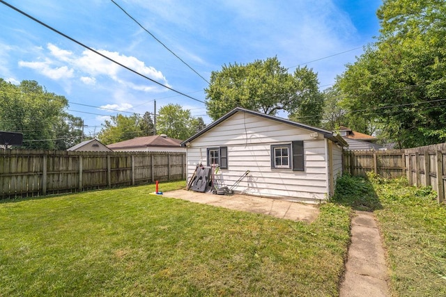 back of property with a fenced backyard and a lawn