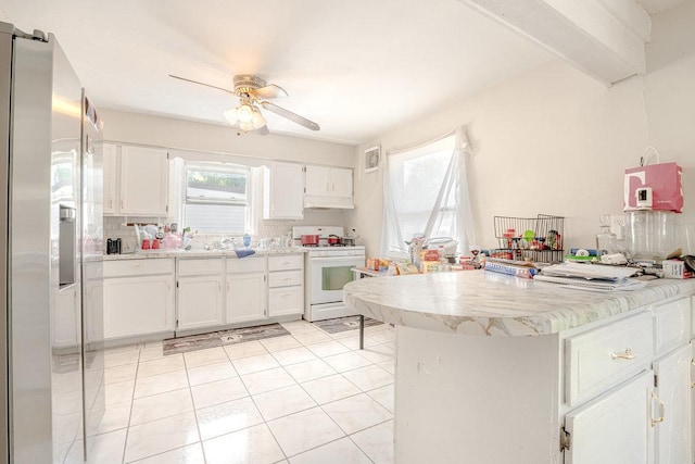 kitchen featuring light tile patterned floors, stainless steel fridge, white cabinets, a peninsula, and white gas stove