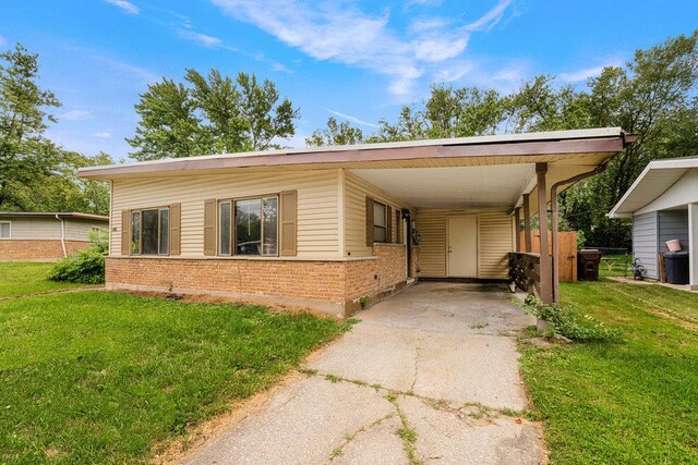 view of front of property with a carport and a front lawn