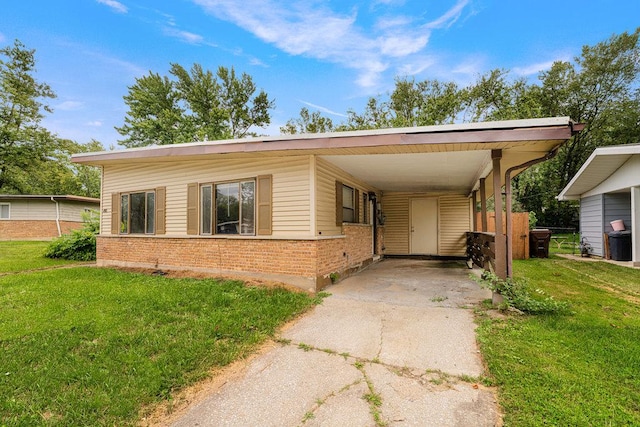 view of front facade with concrete driveway, a front lawn, an attached carport, and brick siding