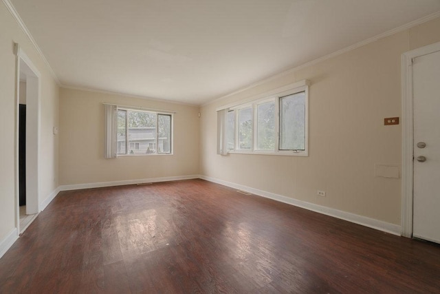 spare room with crown molding, dark wood finished floors, and baseboards