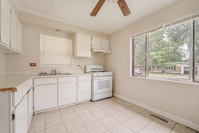 kitchen with gas range gas stove, light countertops, visible vents, a sink, and under cabinet range hood