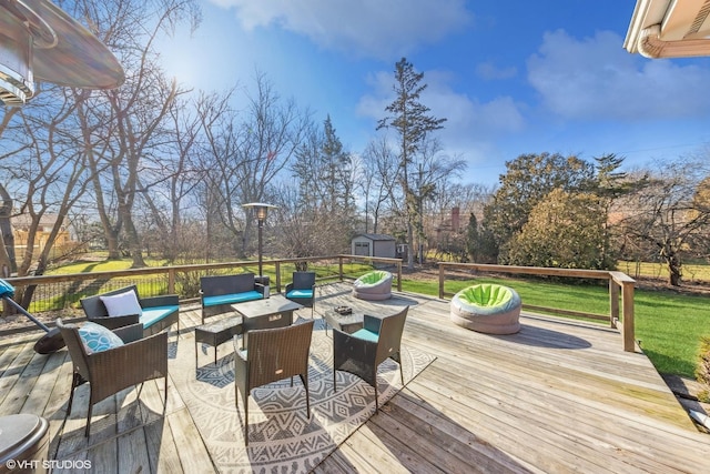 wooden terrace featuring an outdoor living space, a lawn, and a storage shed