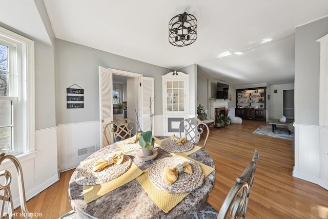 dining room with lofted ceiling and light wood-type flooring