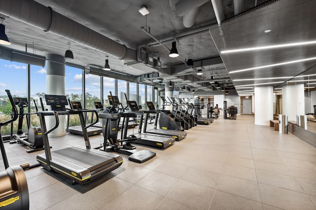 gym featuring expansive windows and light tile patterned flooring