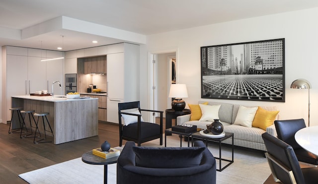 living area with dark wood-type flooring and recessed lighting