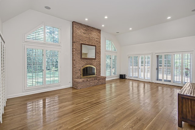 unfurnished living room with a wealth of natural light, a fireplace, and vaulted ceiling