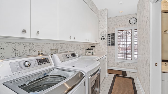 clothes washing area featuring cabinets, independent washer and dryer, sink, and light tile patterned floors