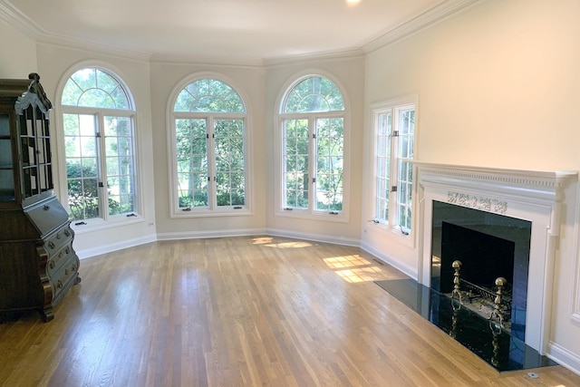 unfurnished living room featuring crown molding, a premium fireplace, and hardwood / wood-style floors