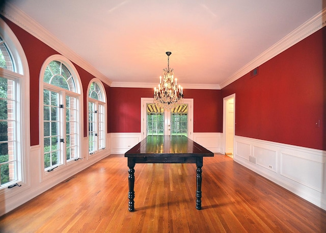 interior space with an inviting chandelier, hardwood / wood-style floors, and crown molding