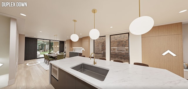 kitchen featuring light wood-type flooring, pendant lighting, a wall of windows, sink, and light stone countertops