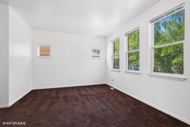 unfurnished room featuring dark colored carpet