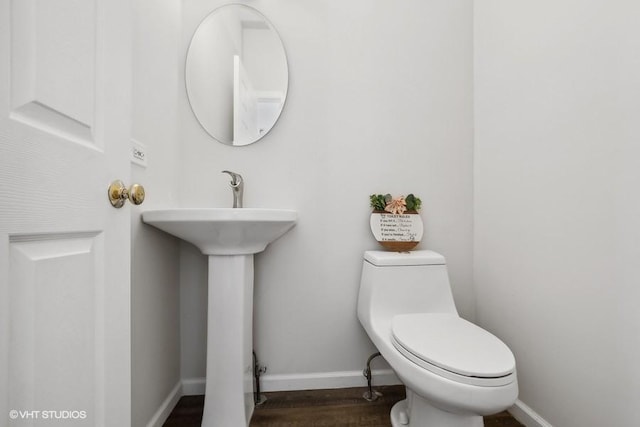 bathroom with wood-type flooring, sink, and toilet