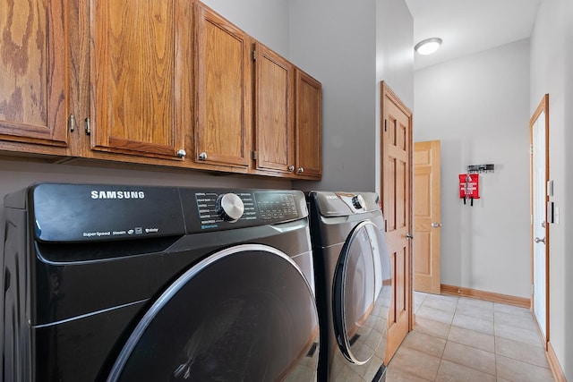 washroom featuring cabinets, light tile patterned floors, and independent washer and dryer