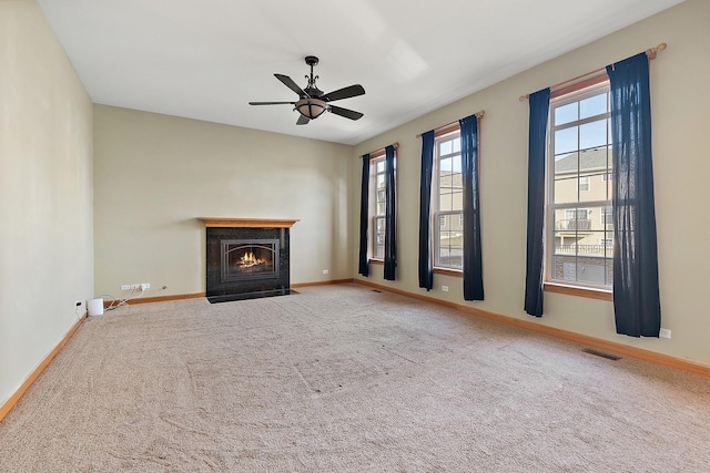 unfurnished living room with ceiling fan and carpet