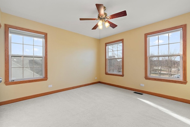 carpeted empty room with a healthy amount of sunlight and ceiling fan