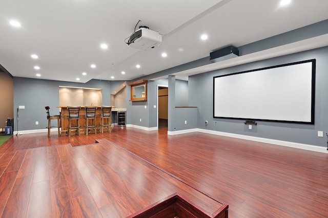 home theater room featuring wood-type flooring and bar area