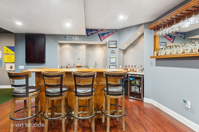 bar with wine cooler and dark hardwood / wood-style flooring