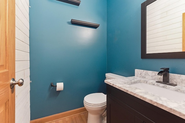 bathroom with vanity, toilet, and wood-type flooring