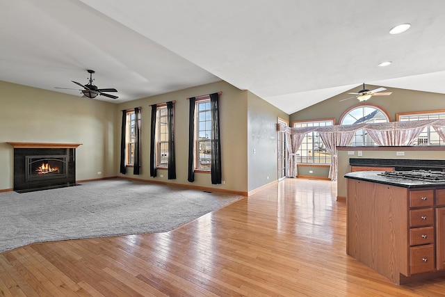 kitchen featuring ceiling fan, lofted ceiling, stainless steel gas stovetop, and light hardwood / wood-style floors