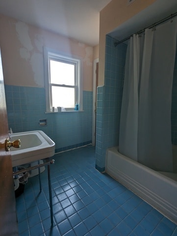 bathroom with tile patterned flooring, tile walls, and shower / tub combo