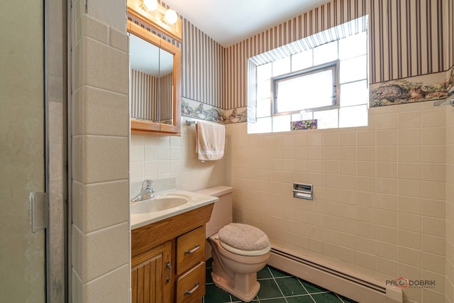 bathroom with vanity, an enclosed shower, a baseboard heating unit, tile walls, and toilet