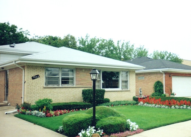 view of front of house with a garage and a front lawn