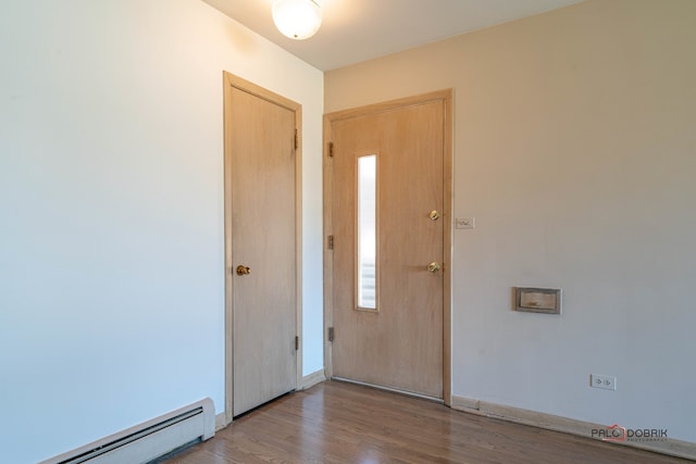 spare room with light wood-type flooring and a baseboard radiator