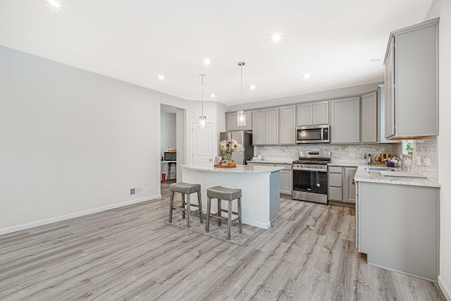 kitchen featuring appliances with stainless steel finishes, gray cabinets, and a center island