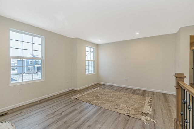 spare room with light wood-type flooring, visible vents, baseboards, and recessed lighting