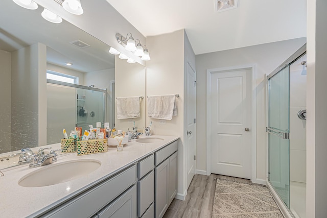 bathroom with a stall shower, visible vents, and a sink