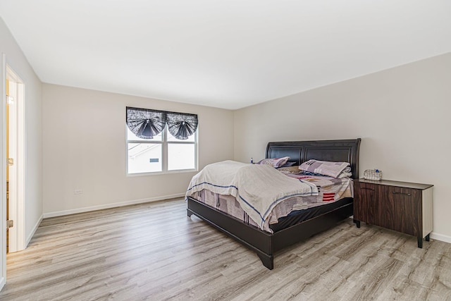 bedroom featuring light wood-style floors and baseboards