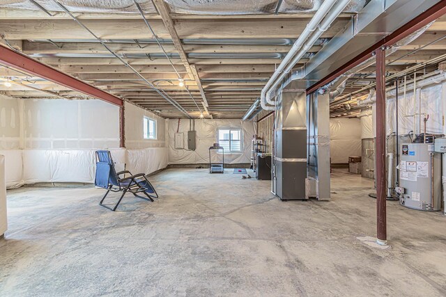 basement with heating unit, electric panel, and gas water heater